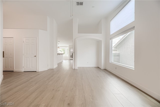 interior space featuring a high ceiling and light wood-type flooring