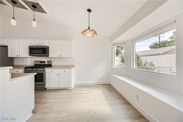 kitchen featuring white cabinets, hanging light fixtures, lofted ceiling, and stainless steel appliances