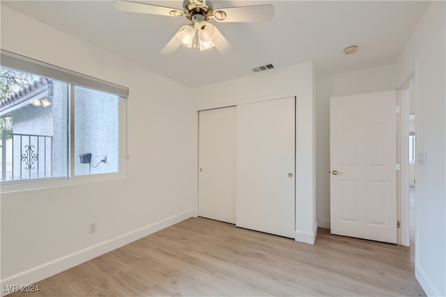 unfurnished bedroom featuring light hardwood / wood-style flooring, ceiling fan, and a closet