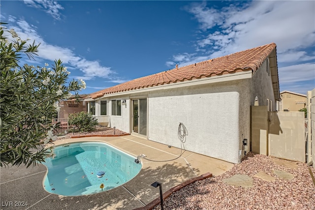 back of property featuring a fenced in pool and a patio area