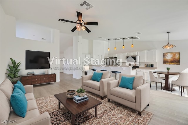 living room featuring light wood-type flooring, lofted ceiling, and ceiling fan