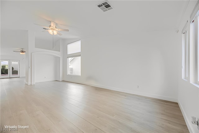 empty room featuring french doors, light hardwood / wood-style flooring, and ceiling fan