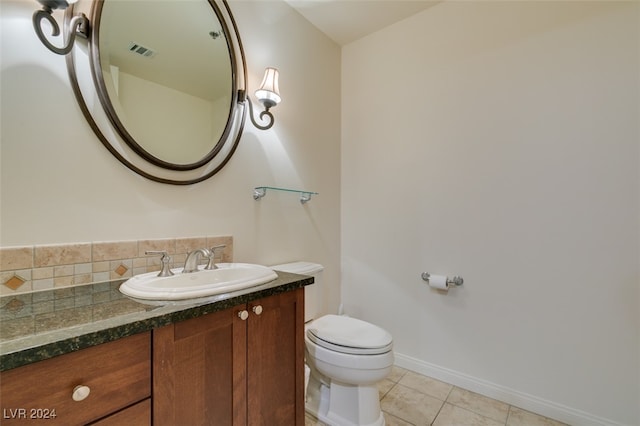 bathroom featuring toilet, tile patterned flooring, vanity, and tasteful backsplash