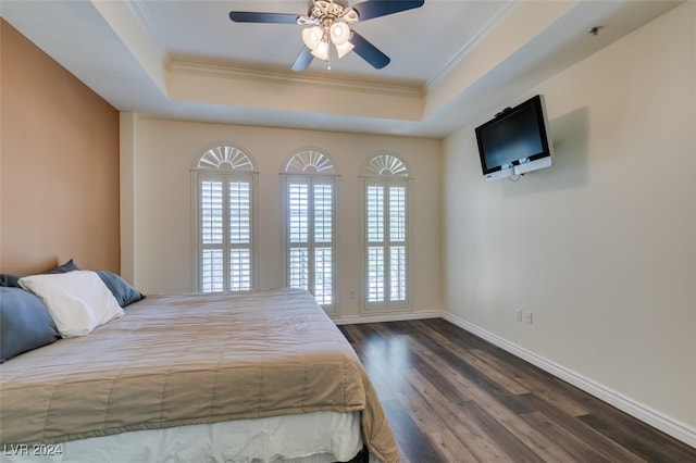 bedroom featuring crown molding, a raised ceiling, dark hardwood / wood-style floors, and ceiling fan