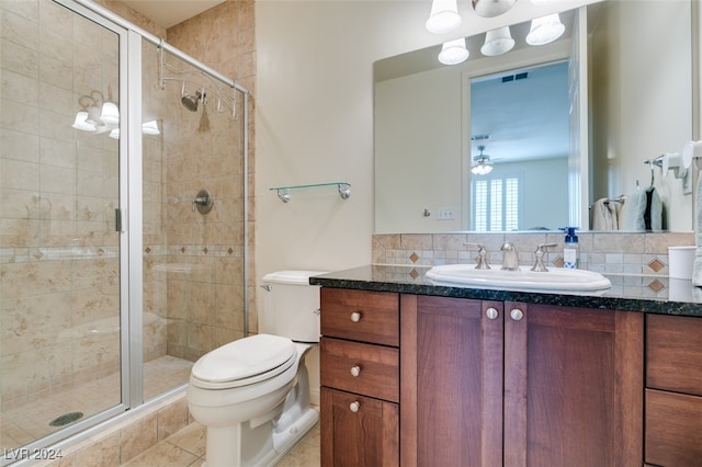 bathroom with toilet, tile patterned flooring, an enclosed shower, vanity, and backsplash