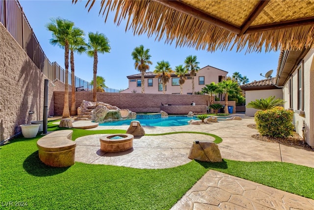 view of pool featuring a patio area, pool water feature, and a fire pit