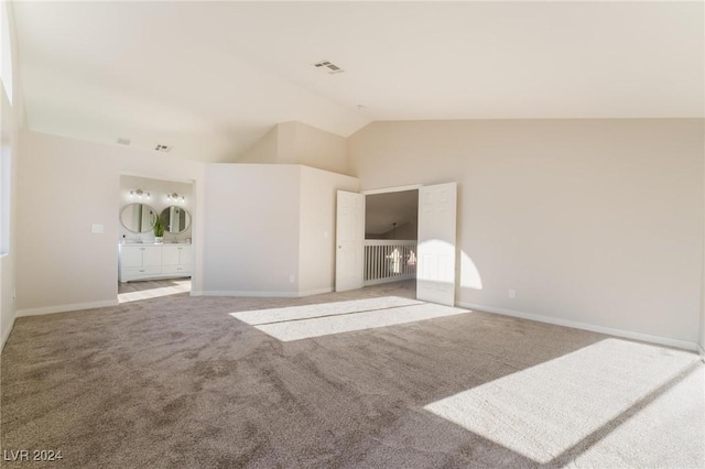 empty room with carpet floors and vaulted ceiling