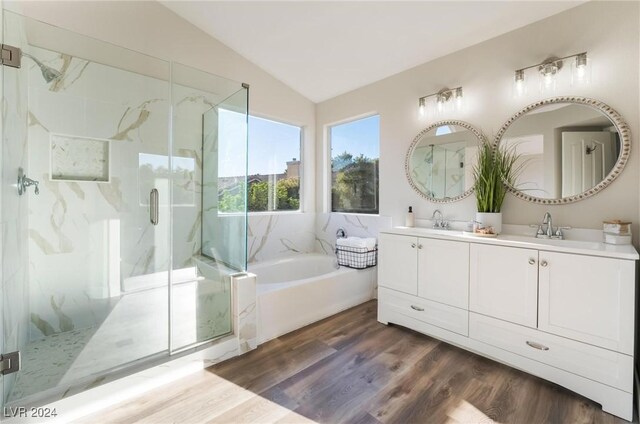 bathroom featuring vanity, wood-type flooring, shower with separate bathtub, and vaulted ceiling