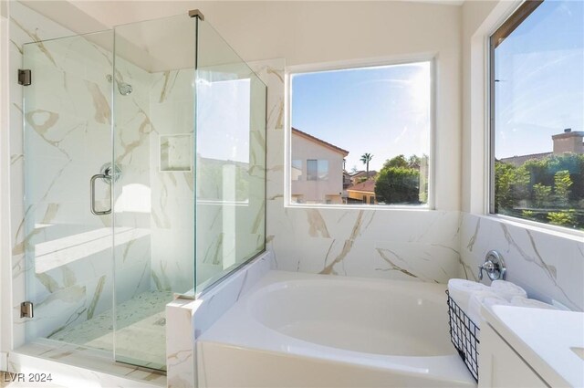 bathroom featuring vanity, tile walls, and independent shower and bath