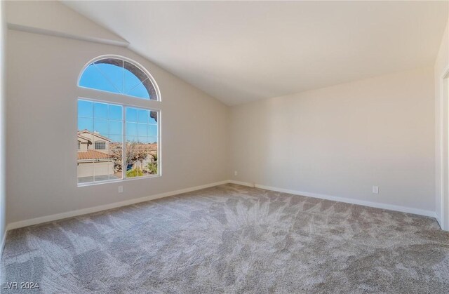 unfurnished room featuring carpet and lofted ceiling