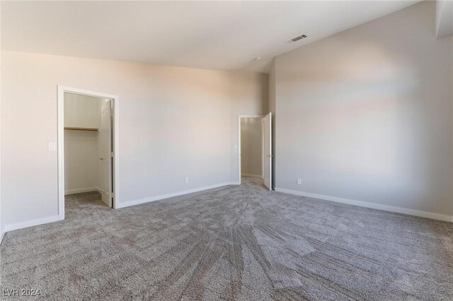 carpeted spare room with vaulted ceiling