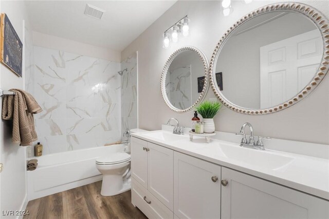 full bathroom with bathtub / shower combination, wood-type flooring, vanity, and toilet