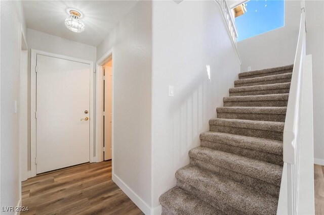 stairs featuring hardwood / wood-style floors