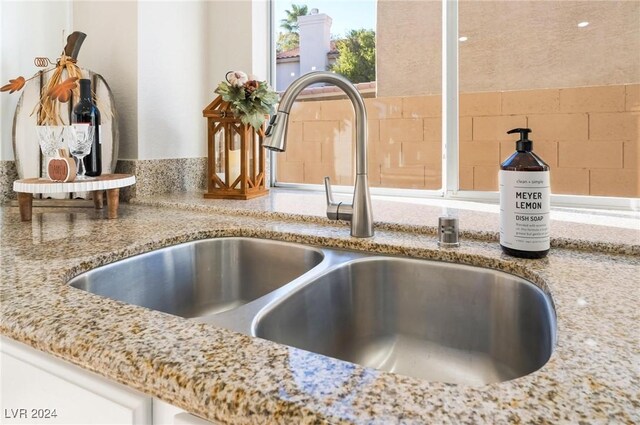 interior details featuring light stone countertops and sink