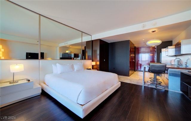 bedroom with sink and hardwood / wood-style flooring