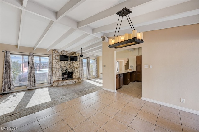 unfurnished living room with vaulted ceiling with beams, ceiling fan, light tile patterned floors, and a fireplace