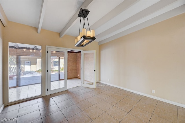 tiled empty room featuring a chandelier, beam ceiling, and french doors