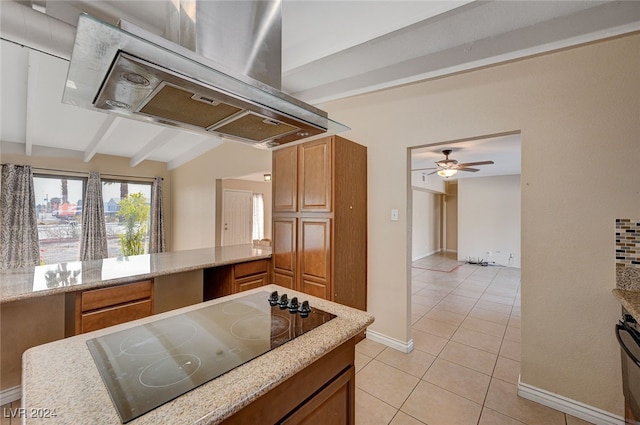 kitchen featuring island range hood, black electric cooktop, ceiling fan, light tile patterned floors, and vaulted ceiling with beams