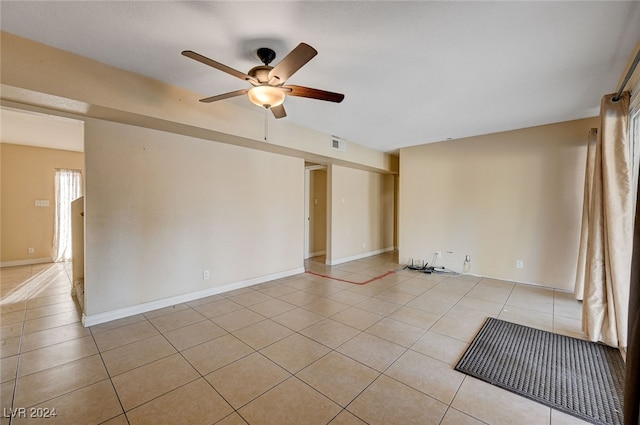 spare room with ceiling fan and light tile patterned floors