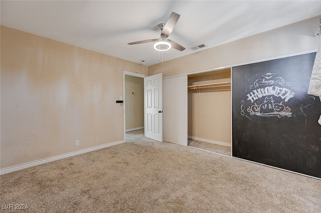 unfurnished bedroom featuring ceiling fan, light colored carpet, and a closet