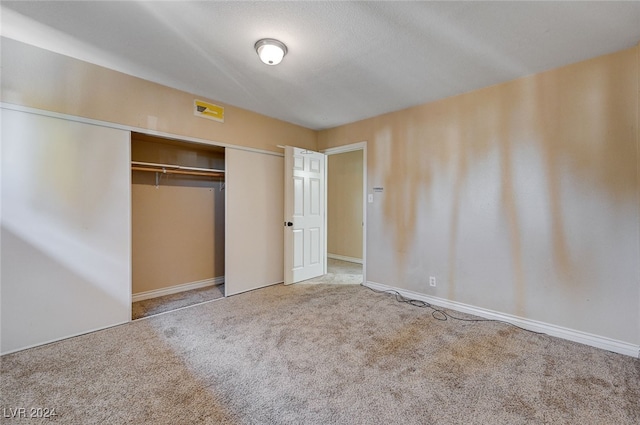 unfurnished bedroom with carpet flooring and a closet