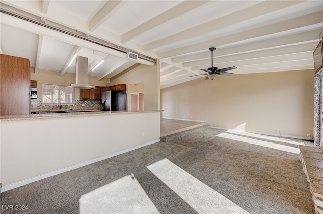 unfurnished living room featuring carpet flooring, vaulted ceiling with beams, and ceiling fan