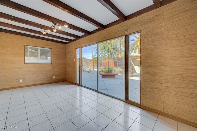 empty room with beamed ceiling, light tile patterned floors, and wood walls