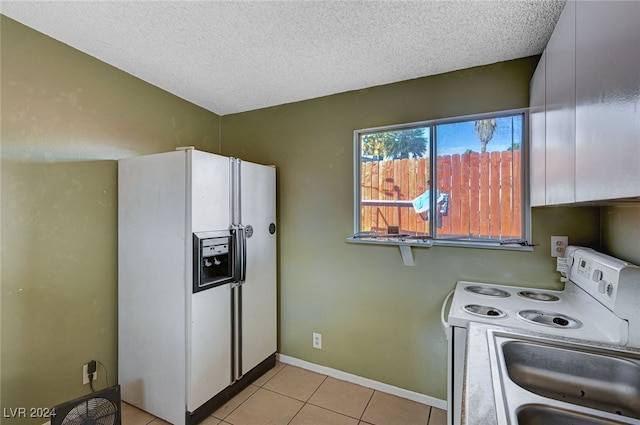 kitchen featuring white appliances, white cabinets, sink, a textured ceiling, and light tile patterned flooring