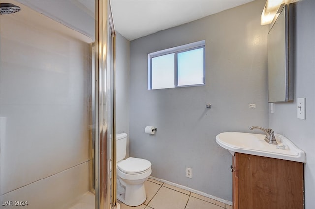 bathroom with tile patterned floors, a shower with door, vanity, and toilet