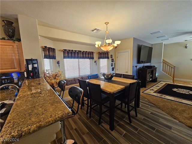 dining room featuring dark hardwood / wood-style flooring and an inviting chandelier