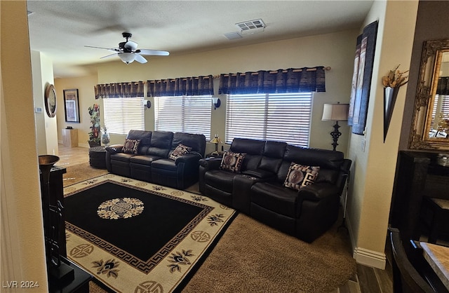 living room featuring hardwood / wood-style floors, ceiling fan, and a textured ceiling