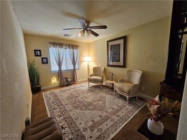 living area with carpet and ceiling fan