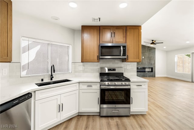 kitchen featuring white cabinetry, appliances with stainless steel finishes, sink, and light wood-type flooring