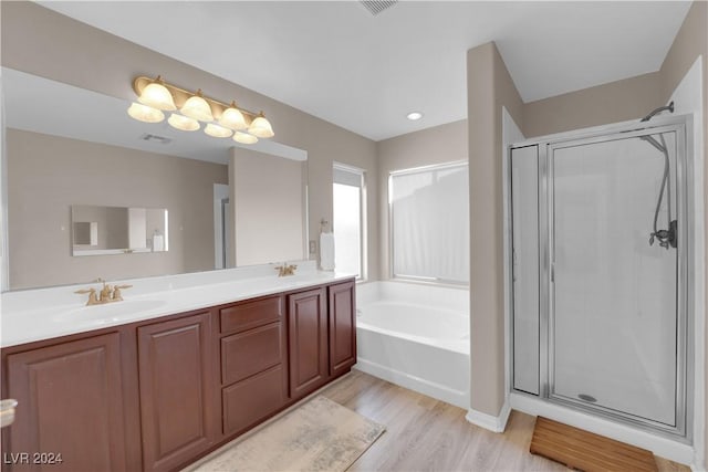 bathroom featuring plus walk in shower, hardwood / wood-style floors, and vanity