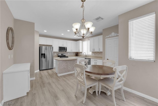 dining space featuring sink, plenty of natural light, and light hardwood / wood-style flooring