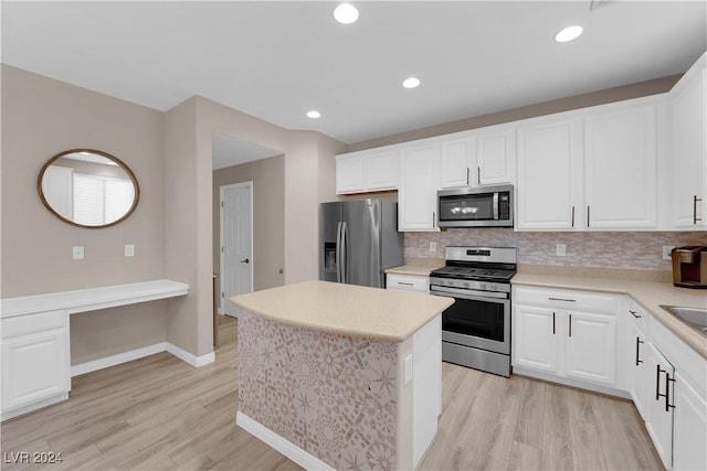 kitchen featuring white cabinets, decorative backsplash, stainless steel appliances, and light hardwood / wood-style flooring