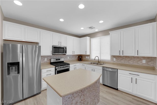 kitchen featuring a center island, light wood-type flooring, stainless steel appliances, and sink