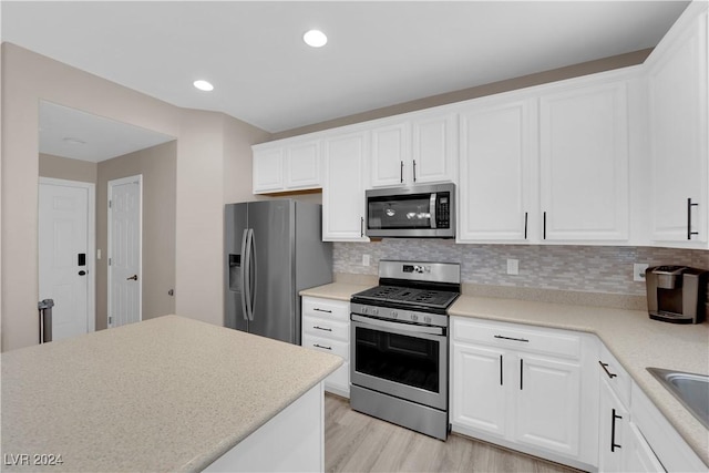 kitchen featuring white cabinets, light hardwood / wood-style floors, stainless steel appliances, and tasteful backsplash