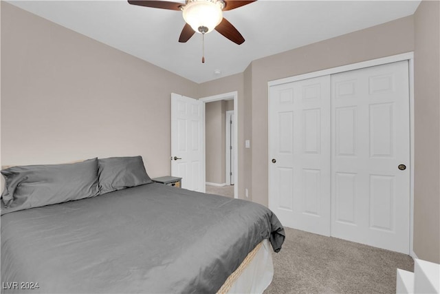 carpeted bedroom with ceiling fan and a closet