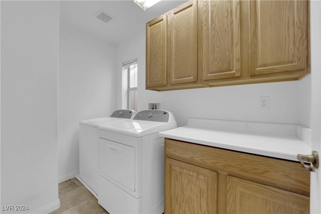 laundry area with light tile patterned floors, cabinets, and independent washer and dryer