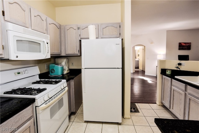 kitchen with light brown cabinets, white appliances, light hardwood / wood-style floors, and sink