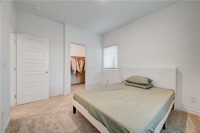 carpeted bedroom featuring a closet and a spacious closet