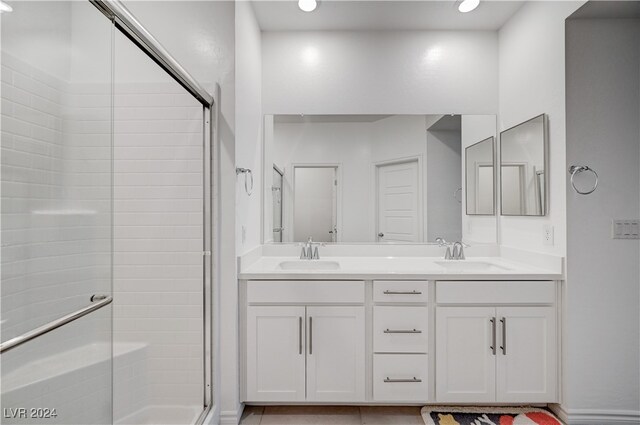 bathroom with walk in shower, vanity, and tile patterned floors