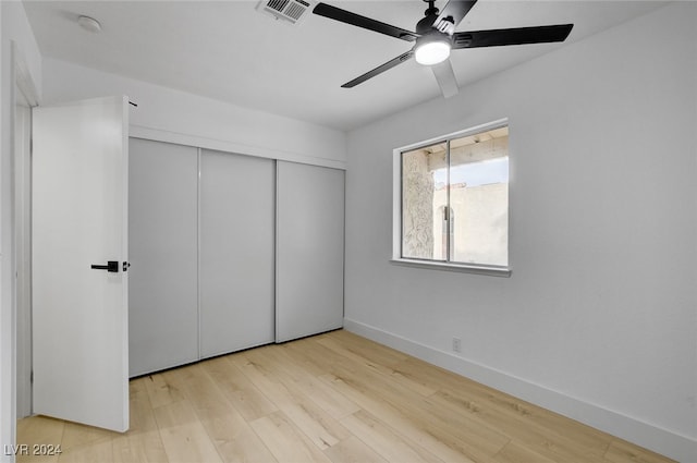 unfurnished bedroom with ceiling fan, a closet, and light hardwood / wood-style flooring