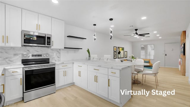 kitchen featuring white cabinets, kitchen peninsula, and appliances with stainless steel finishes