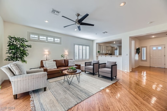 living room featuring light hardwood / wood-style floors and ceiling fan