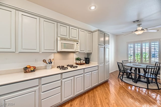 kitchen featuring gray cabinets, white appliances, ceiling fan, and light hardwood / wood-style flooring