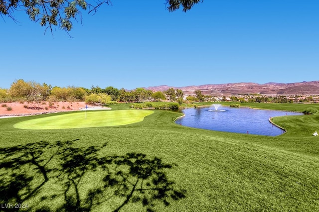 surrounding community featuring a water and mountain view and a yard