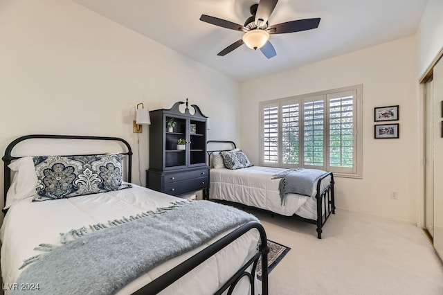 carpeted bedroom with ceiling fan, a closet, and lofted ceiling