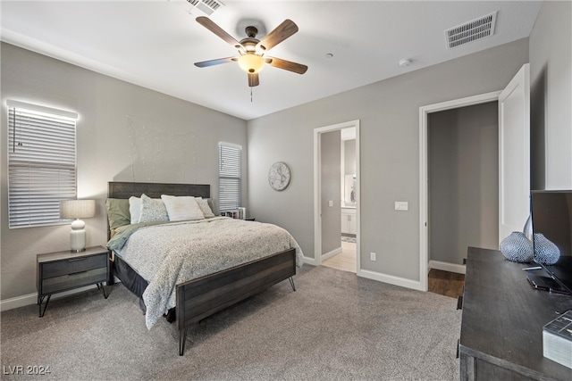 bedroom with ensuite bathroom, carpet floors, and ceiling fan